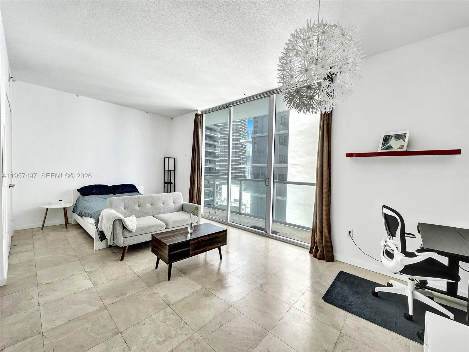 1050 Brickell Avenue, Unit 2722 Miami, FL 33131 - Photo 13 of 19 a living room with furniture and a chandelier