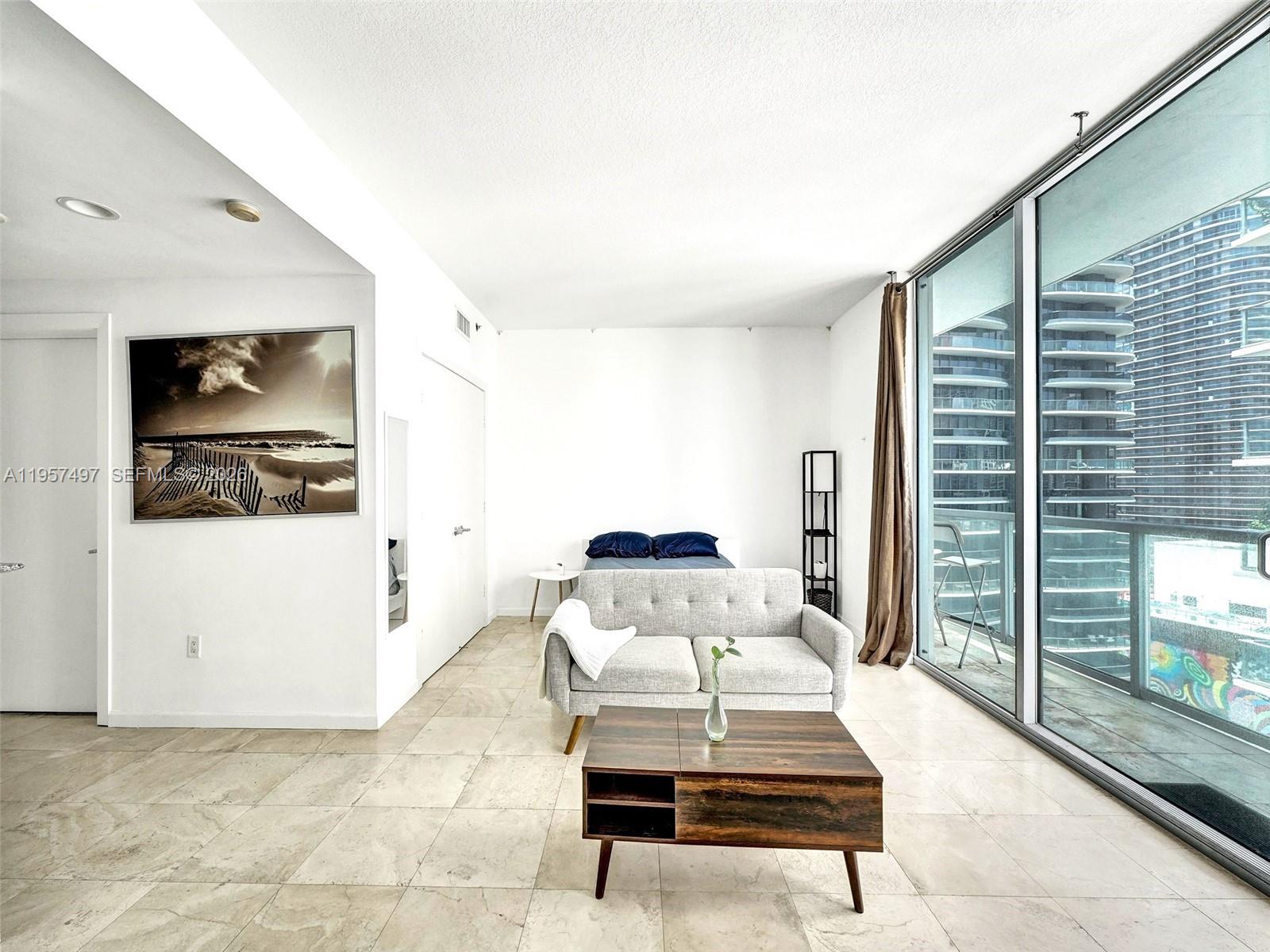 1050 Brickell Avenue, Unit 2722 Miami, FL 33131 - Photo 15 of 19 a living room with furniture and a painting on the wall