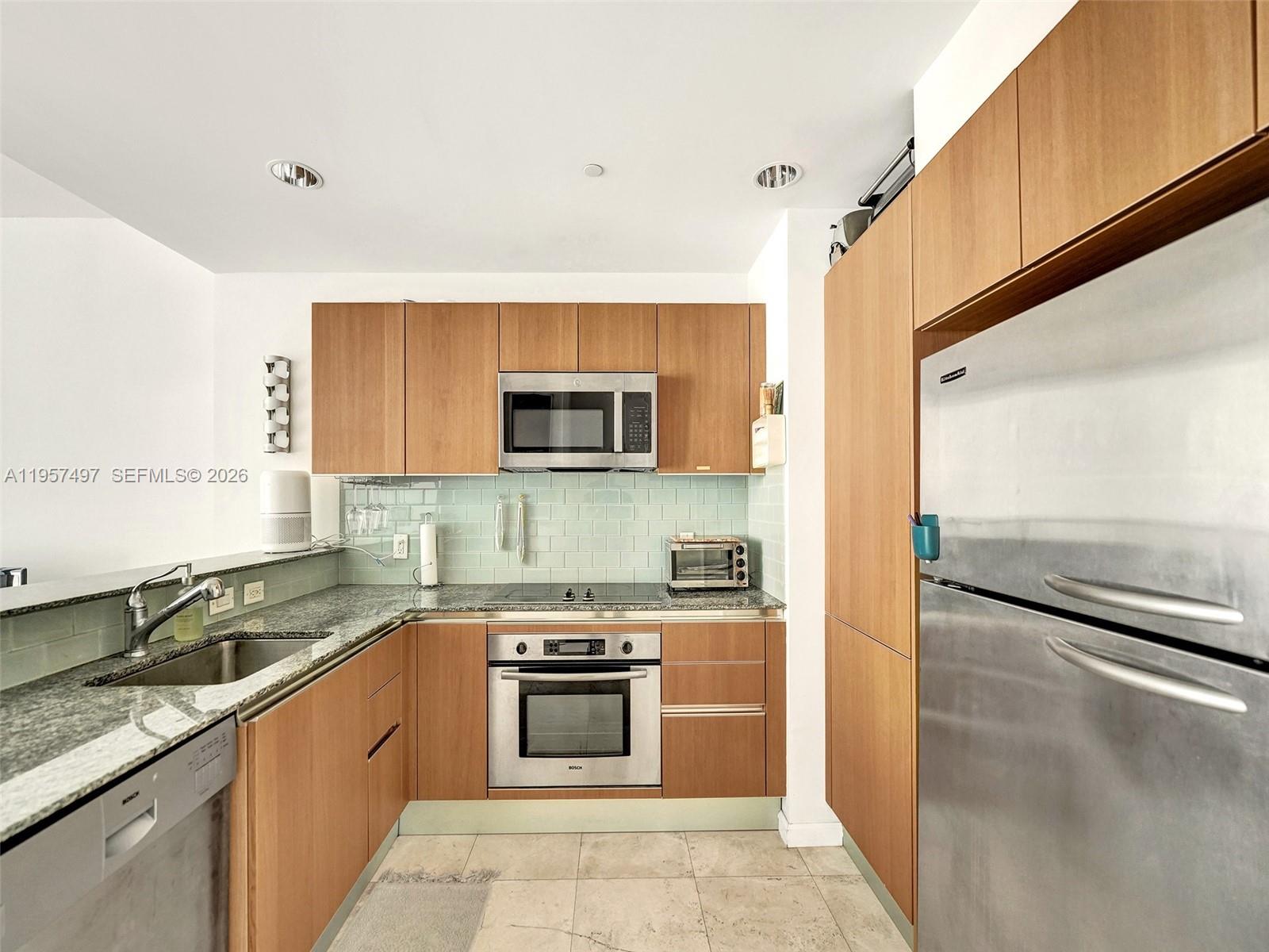 1050 Brickell Avenue, Unit 2722 Miami, FL 33131 - Photo 2 of 19 a kitchen with stainless steel appliances granite countertop a sink and a stove top oven
