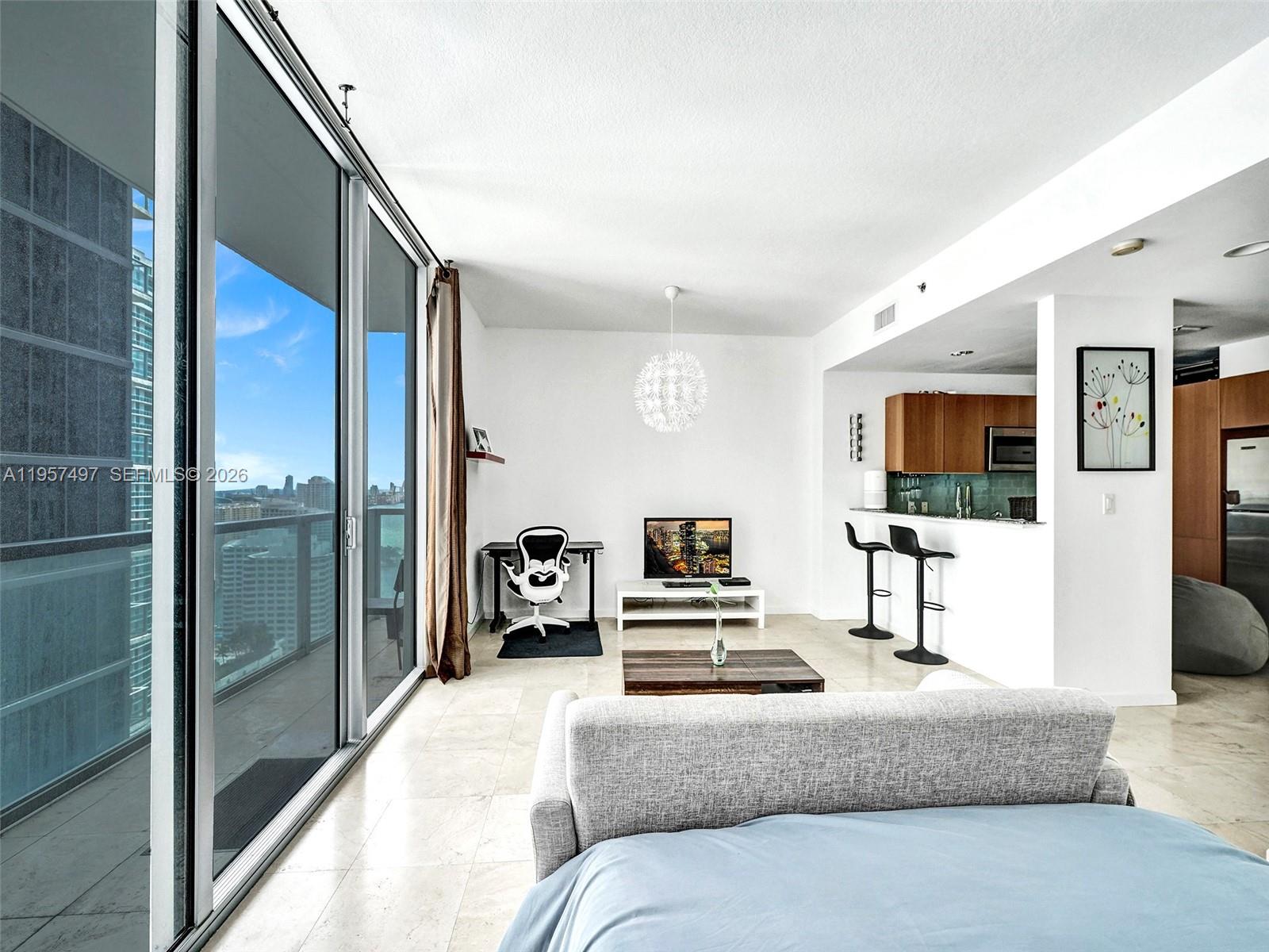 1050 Brickell Avenue, Unit 2722 Miami, FL 33131 - Photo 6 of 19 a bedroom with a bed a flat screen tv and a large window
