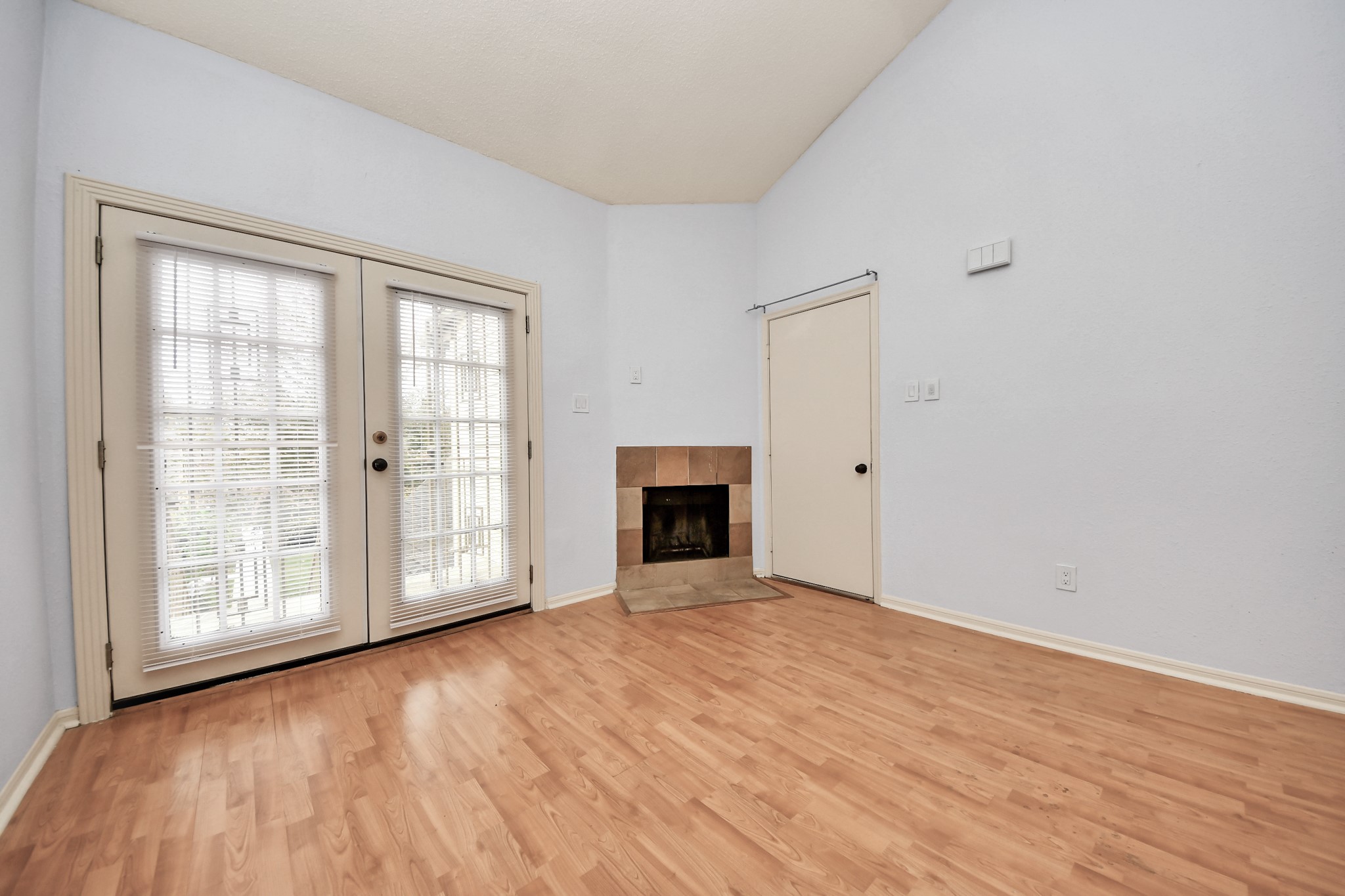2425 Holly Hall Street, Unit C54 Houston, TX 77054 - Photo 3 of 22 an empty room with wooden floor fireplace and windows