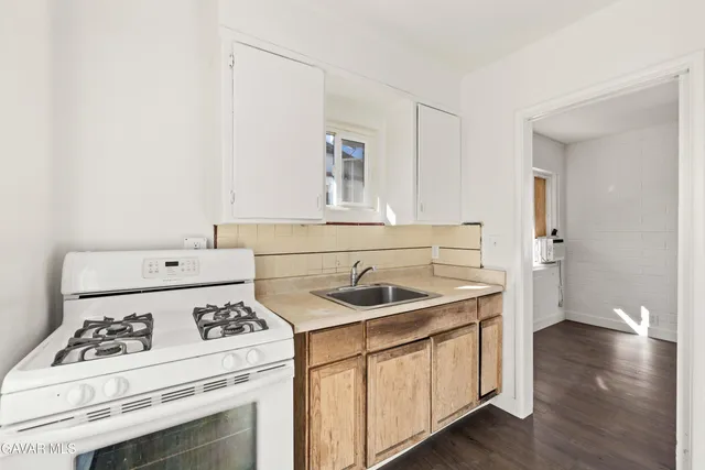 a kitchen with a sink stove and cabinets