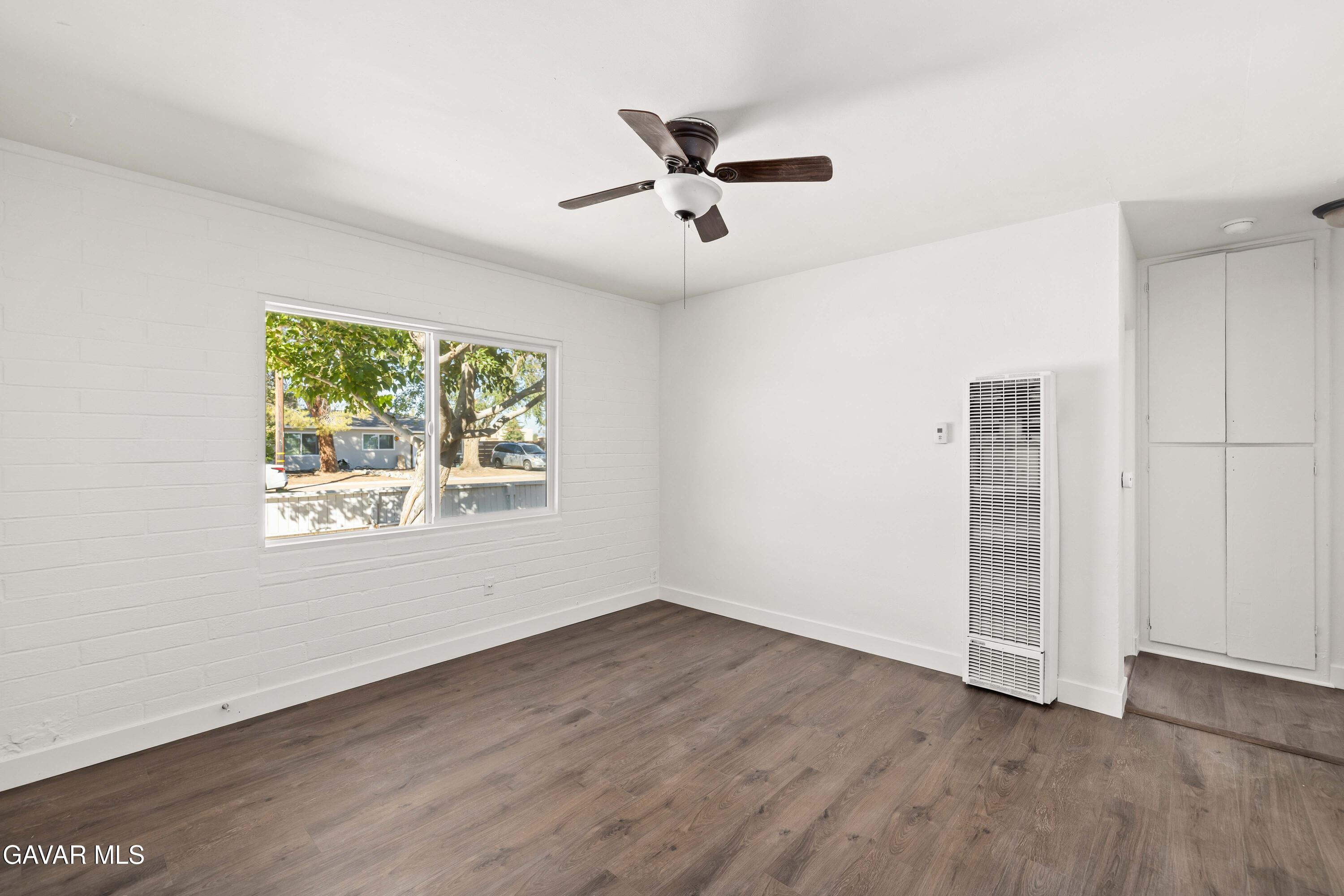 45148 Date Avenue Lancaster, CA 93534 - Photo 4 of 32 an empty room with wooden floor ceiling fan and windows
