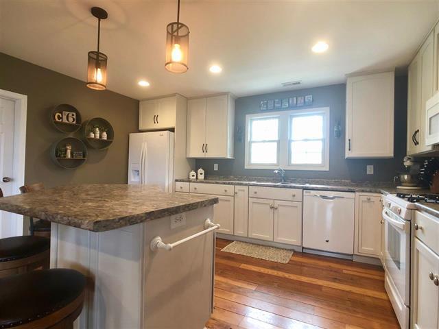 9987 East High Road Stillman Valley, IL 61084 - Photo 11 of 25 a kitchen with stainless steel appliances granite countertop a sink a stove and a wooden floors