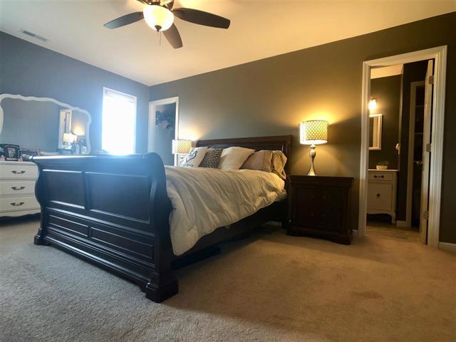 9987 East High Road Stillman Valley, IL 61084 - Photo 20 of 25 a bedroom with a bed and a chandelier