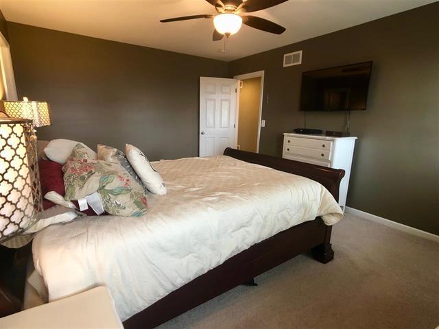 9987 East High Road Stillman Valley, IL 61084 - Photo 21 of 25 a bedroom with a bed and a flat screen tv