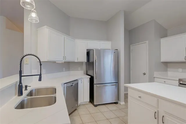 a kitchen with a sink cabinets and refrigerator