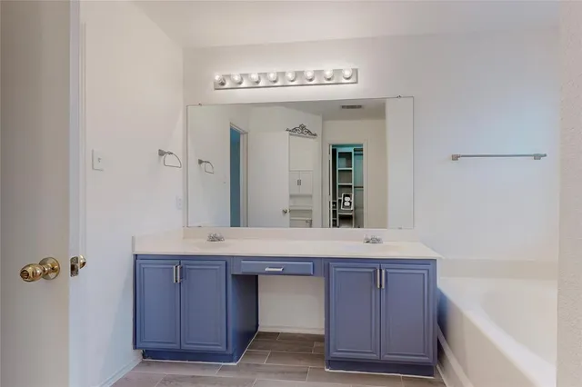 a bathroom with a granite countertop sink mirror and bathtub