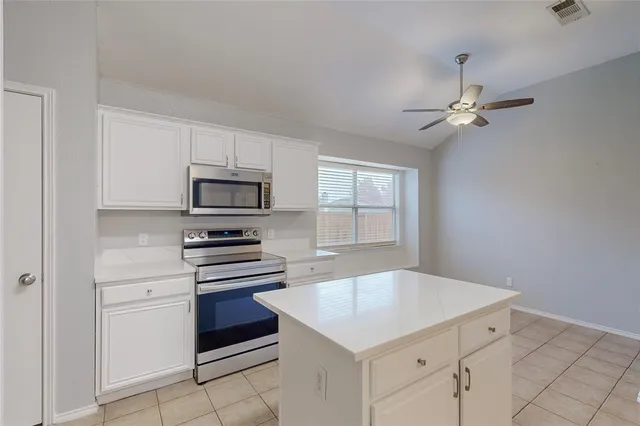 a kitchen with cabinets stainless steel appliances and a window