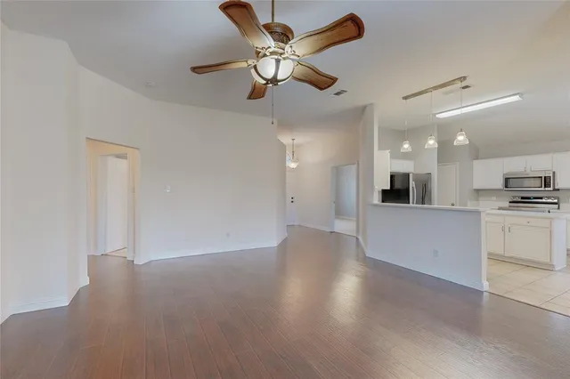 a view of an empty room and kitchen view