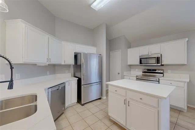 a kitchen with appliances a sink and cabinets