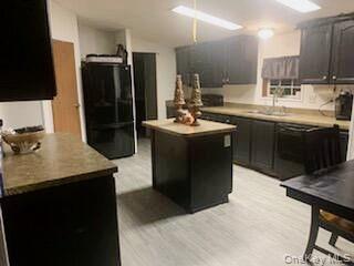 76 Parks Road Livingston Manor, NY 12758 - Photo 3 of 15 Kitchen featuring black refrigerator, a center island, light countertops, and light wood-style floors