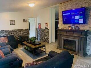 76 Parks Road Livingston Manor, NY 12758 - Photo 5 of 15 Living area featuring a fireplace, wood finished floors, and vaulted ceiling