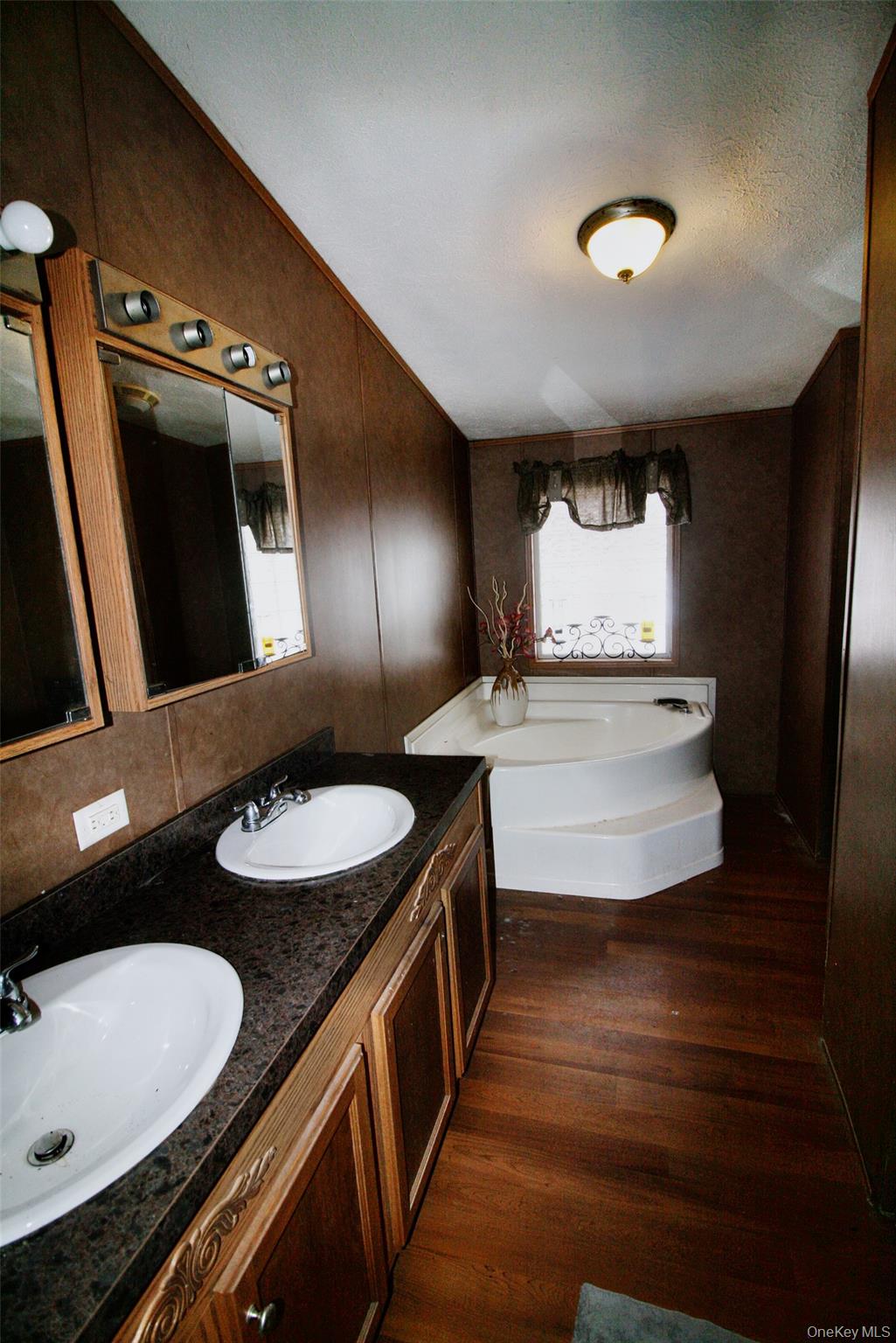 76 Parks Road Livingston Manor, NY 12758 - Photo 9 of 15 Full bath with a bath, double vanity, dark wood-style floors, a textured ceiling, and lofted ceiling