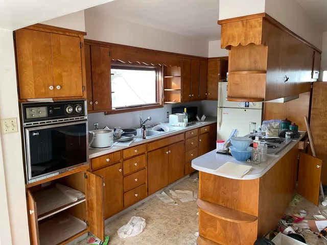 a kitchen with sink refrigerator and stove