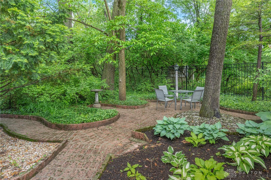467 West Rahn Road Dayton, OH 45429 - Photo 34 of 41 This lush backyard features a charming brick patio, perfect for relaxing amidst nature.