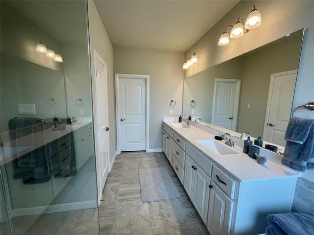 a bathroom with double vanity and mirrors