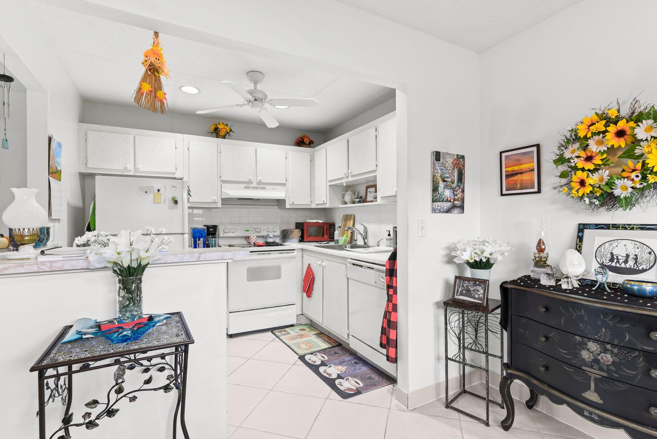 287 Seville L, Unit L Delray Beach, FL 33446 - Photo 13 of 39 a kitchen with white cabinets and stove