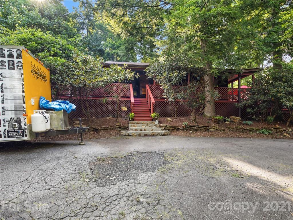 139 Holly Road Black Mountain, NC 28711 - Photo 2 of 21 a view of a patio with a table and chairs under an umbrella