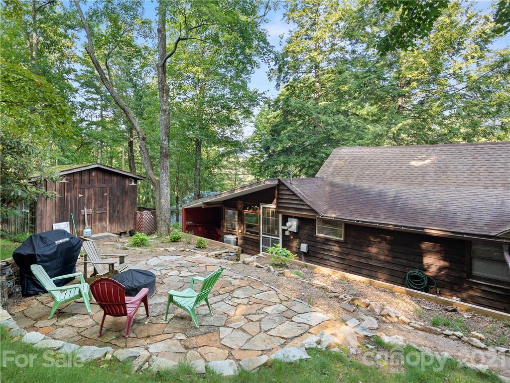 139 Holly Road Black Mountain, NC 28711 - Photo 20 of 21 a backyard of a house with table and chairs under an umbrella