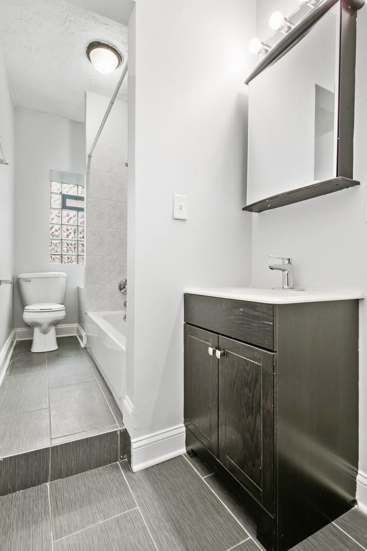 4555 North Malden Street, Unit 102 Chicago, IL 60640 - Photo 6 of 10 a bathroom with a sink and mirror