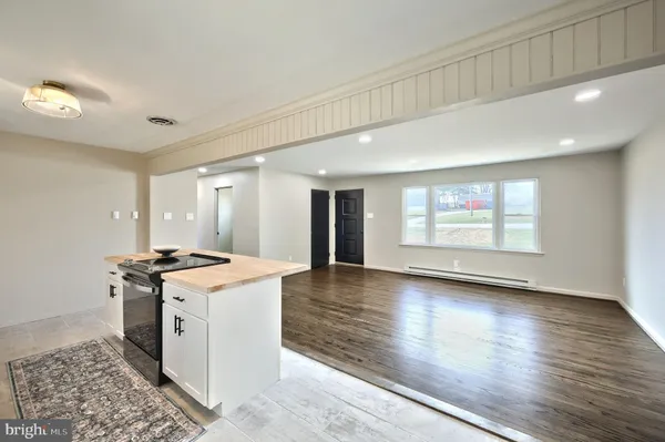 a kitchen with kitchen island a sink a stove a refrigerator and cabinets