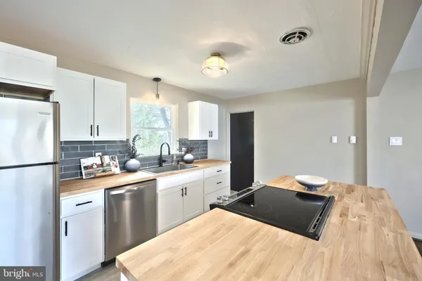 a view of kitchen with furniture a refrigerator and a washer dryer