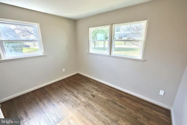 a view of empty room with wooden floor and fireplace