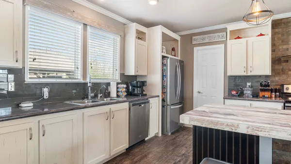 a kitchen with granite countertop white cabinets and stainless steel appliances