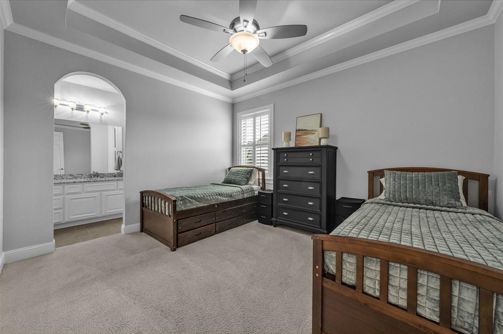 1060 Waters Edge Court Oak Point, TX 75068 - Photo 10 of 40 a bedroom with a bed and a chandelier