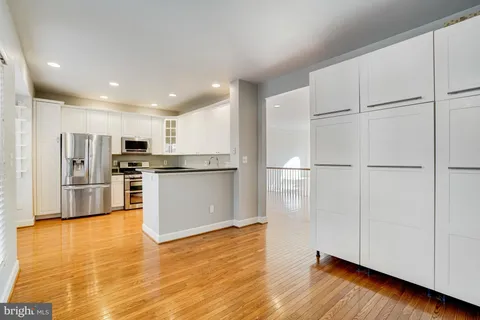 a view of kitchen view wooden floors appliances and cabinets