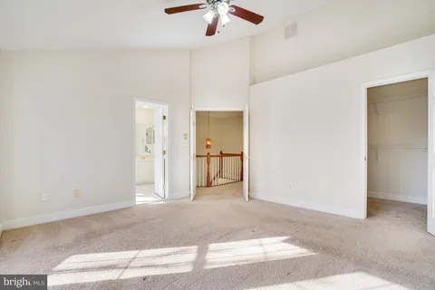 a view of a livingroom with a chandelier fan and kitchen view