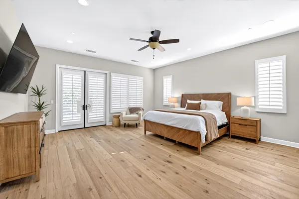 a bedroom with a bed a flat screen tv and a large window