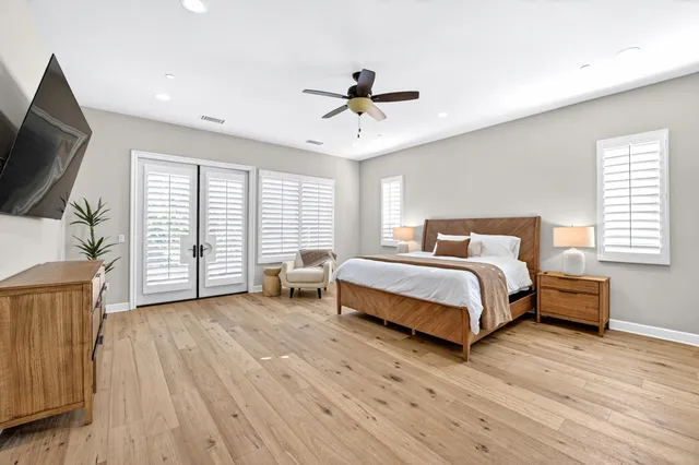 a bedroom with a bed a flat screen tv and a large window