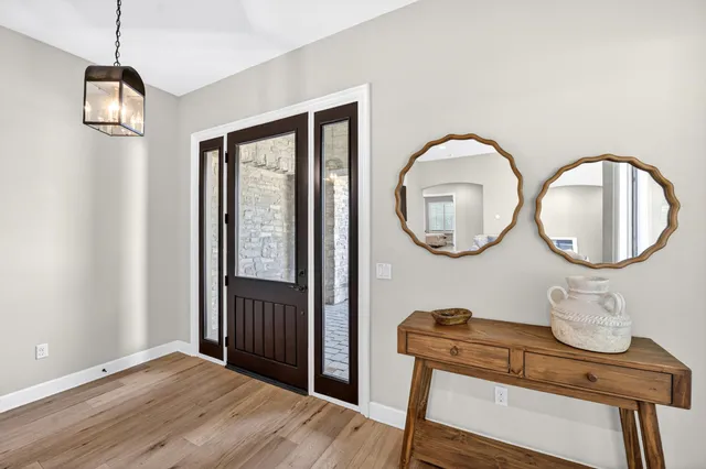 a view of a room with wooden floor mirror and windows