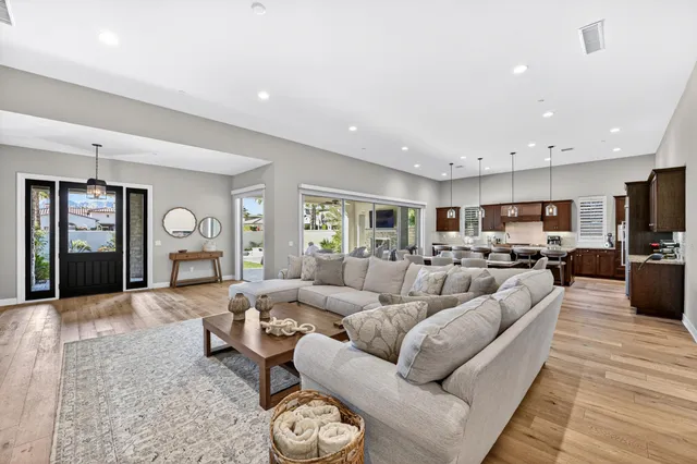 a living room with furniture kitchen view and a window
