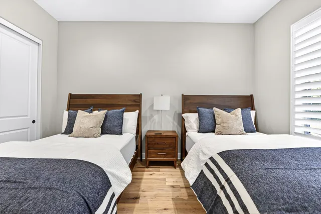 a bedroom with two beds and a night stand