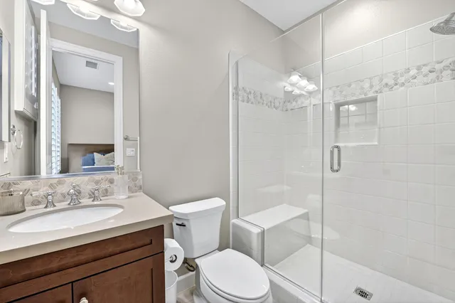 a bathroom with a sink toilet a mirror and shower