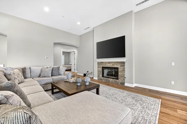 a living room with couches a fireplace and a flat screen tv