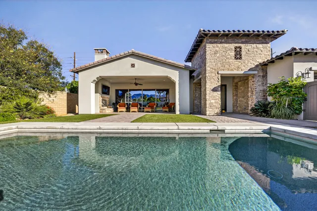 a living room with furniture a flat screen tv and a floor to ceiling window