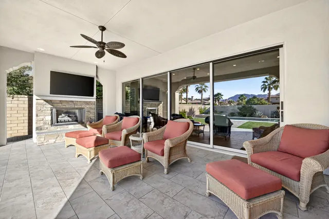 a living room with patio furniture and a fireplace