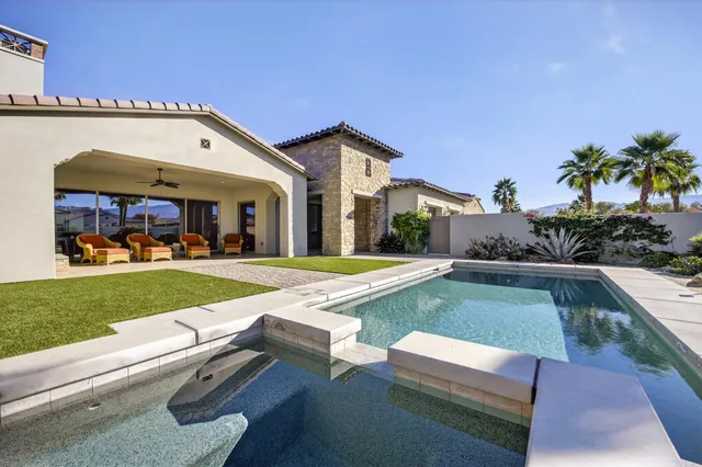 a view of a house with a yard and potted plants
