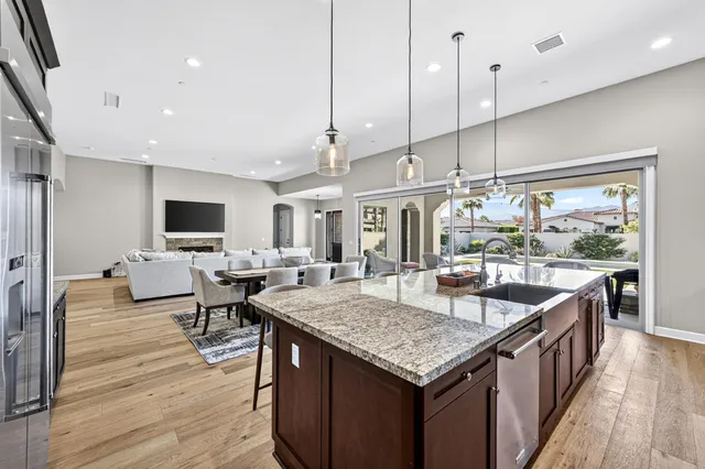 a kitchen with granite countertop a table chairs sink and wooden floor