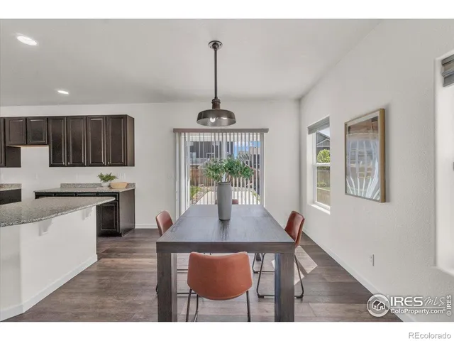 a kitchen with stainless steel appliances a dining table chairs and a refrigerator