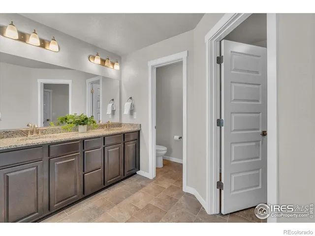 a spacious bathroom with a granite countertop sink mirror and a toilet
