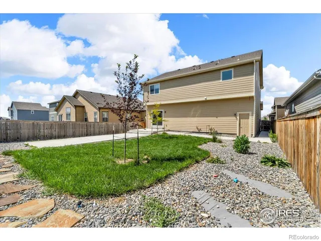 a view of a house with a yard and potted plants