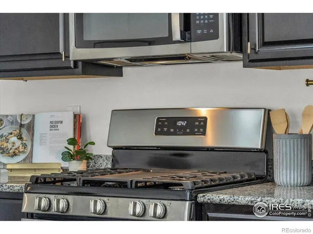 a kitchen with stainless steel appliances granite countertop a stove and a microwave