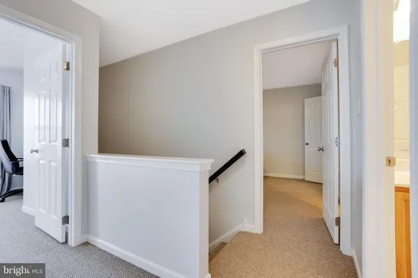 a view of a hallway with white walls and stairs