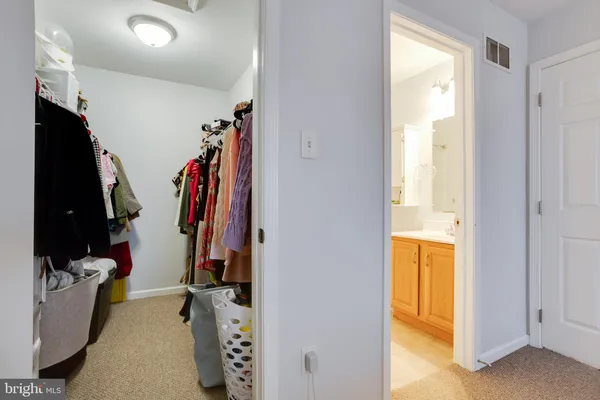 a view of walk in closet with clothes and shoes