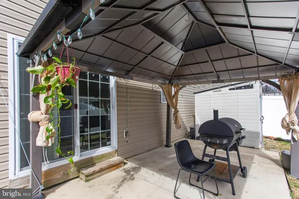 a view of a chairs and table in patio with a barbeque